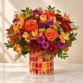 Orange roses, peach alstroemeria and purple mums in an amber stained-glass vase
