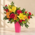 Hot pink roses, yellow lilies, orange alstroemeria and red carnations in a tapered hot-pink vase