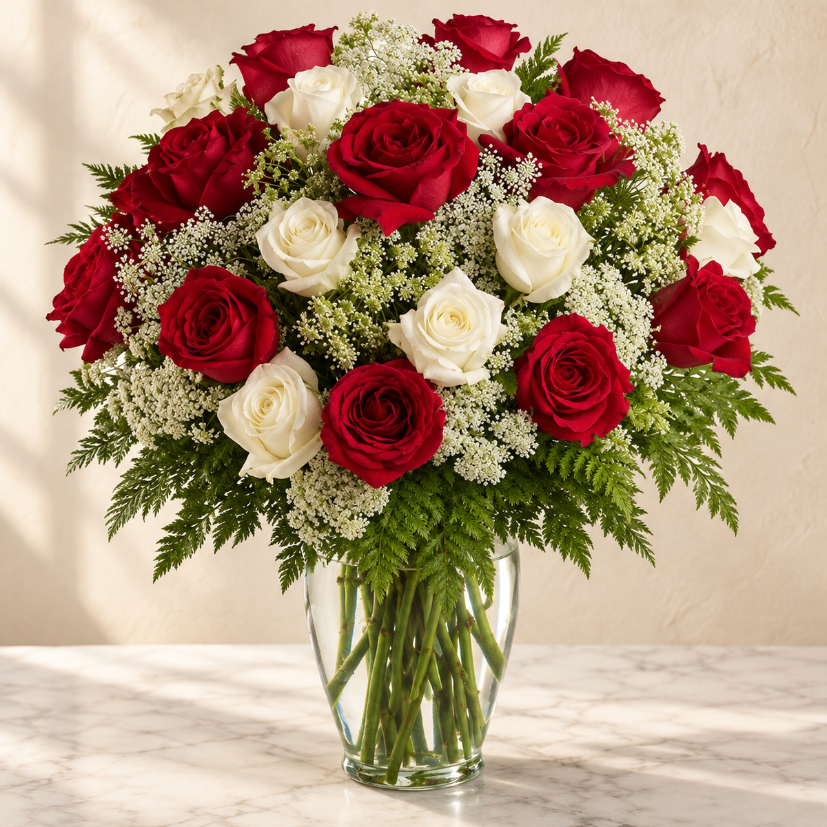 Long-stemmed red and white roses with Queen Anne’s lace in a clear glass vase