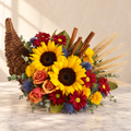 Wicker cornucopia with sunflowers, orange roses, red daisies, wheat and cinnamon sticks