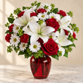 Red roses, white lilies and white daisies in a red glass vase