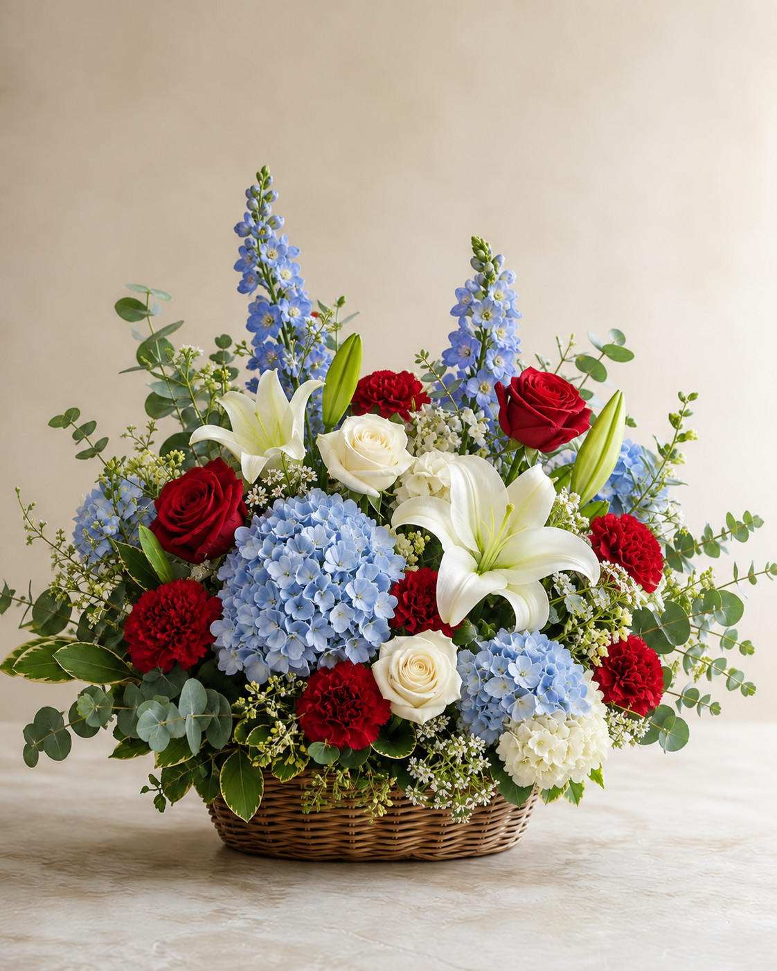 Natural red, white, and powder-blue sympathy flowers in a wicker basket