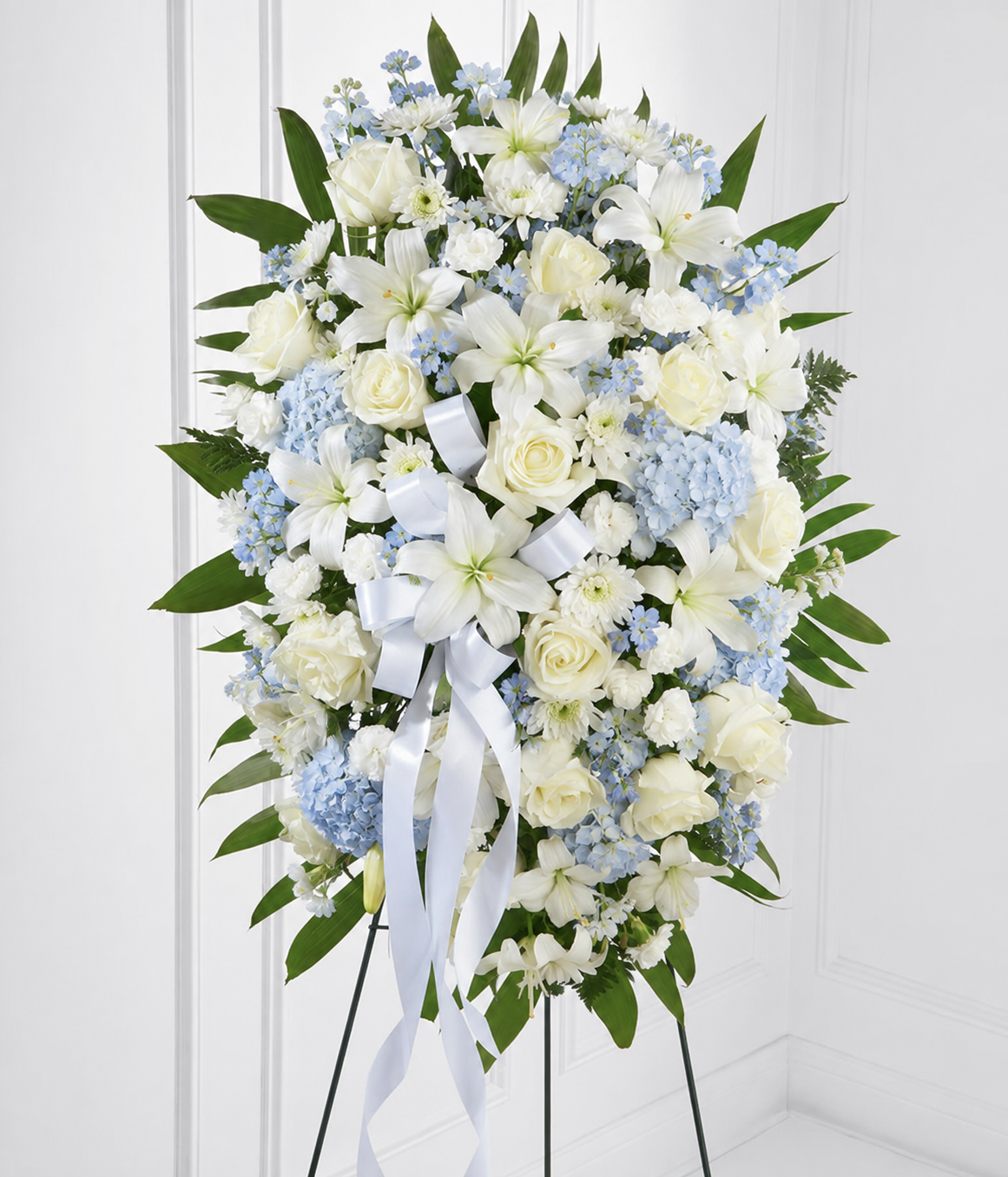 Powder blue standing spray with cream white roses, lilies and carnations