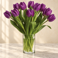 Deep purple tulips in a clear glass cylinder vase